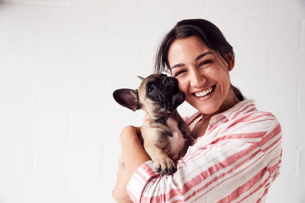 Estudio retrato de sonriente joven sosteniendo cariñosa mascota —  Fotos de Stock