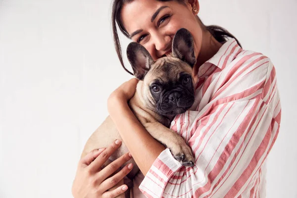 애정어린 애완 동물을 들고 미소짓고 있는 젊은 여자의 스튜디오 사진 — 스톡 사진