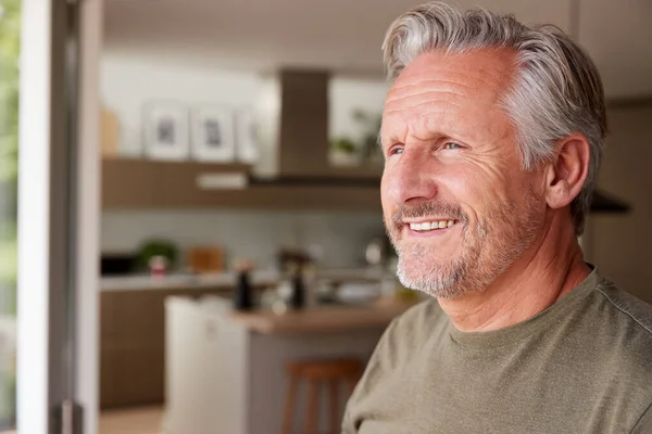 Smiling Senior Man Standing Looking Out Kitchen Door — Stock Photo, Image