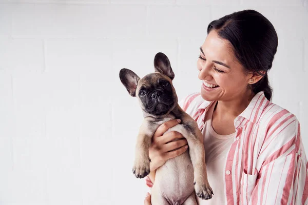 Studioaufnahme einer lächelnden jungen Frau, die ein liebevolles Haustier hält — Stockfoto