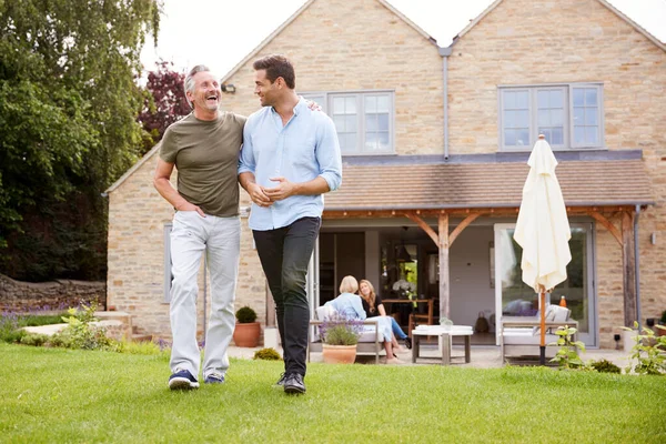 Senior Far Och Vuxen Son Promenader Och Prata Trädgården Tillsammans — Stockfoto