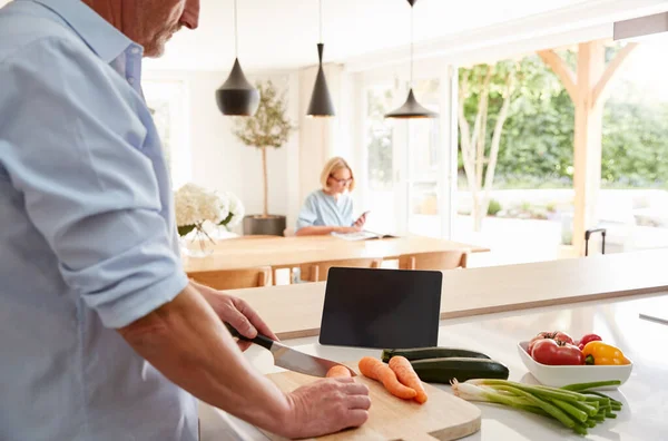 Senior Man Recept Digitale Tablet Als Vrouw Zit Bij Eetkamer — Stockfoto