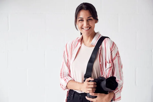 Portret van lachende vrouwelijke fotografe met camera tegen Whit — Stockfoto