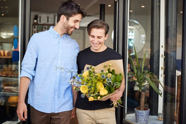 Amoroso macho gay pareja celebración manos saliendo de floristerías hold —  Fotos de Stock