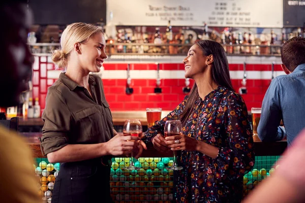 2人の女性が仕事の後のバーで酒と社交のために会う — ストック写真