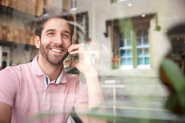 Jonge Man Coffeeshop Praten Mobiele Telefoon Bekeken Door Venster — Stockfoto