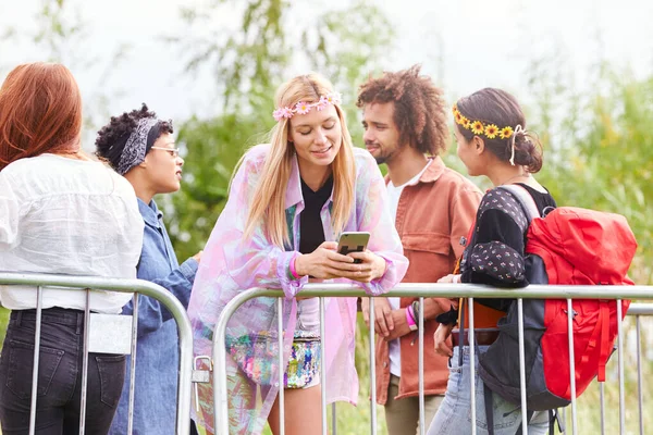 งสาวมองไปท โทรศ อในขณะท เธอรออย องหล Barrier ทางเข าเทศกาลดนตร บไซต — ภาพถ่ายสต็อก