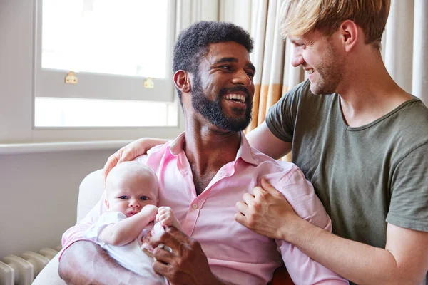 愛する男性同じセックスカップルカッディング赤ちゃん娘上のソファ自宅で一緒に — ストック写真