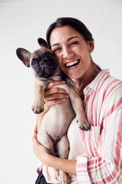 Estudio retrato de sonriente joven sosteniendo cariñosa mascota —  Fotos de Stock