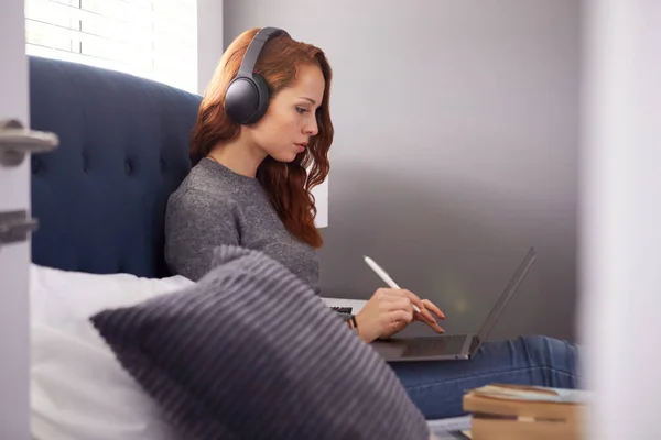 Vrouwelijke Student Draagt Draadloze Koptelefoon Zittend Bed Gedeeld Huis Met — Stockfoto