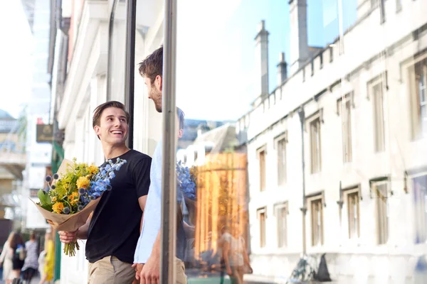 Amante masculino gay casal segurando as mãos saindo de floristas segurar — Fotografia de Stock