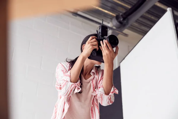 Kobieta fotograf z aparatem fotograficznym na sesji zdjęciowej przeciwko białej Stu — Zdjęcie stockowe