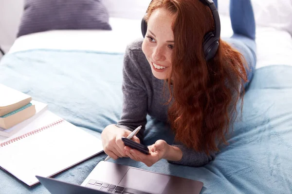 Mirando Hacia Abajo Estudiante Universitaria Femenina Con Auriculares Acostado Cama —  Fotos de Stock