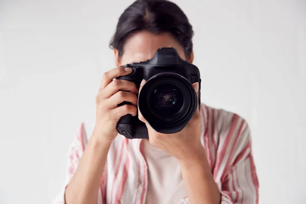 Kobieta fotograf z aparatem fotograficznym na sesji zdjęciowej przeciwko białej Stu — Zdjęcie stockowe