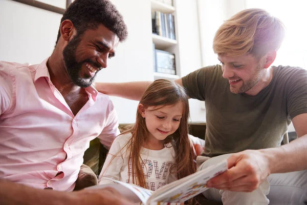 Gleichgeschlechtliches Männliches Paar Liest Buch Mit Tochter Hause Während Sie — Stockfoto