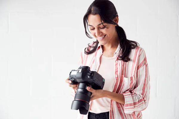 Женщина-фотограф с камерой на фото съемки против белого Стю — стоковое фото