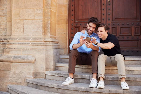 男同性恋夫妇外出度假坐在建筑台阶上 — 图库照片