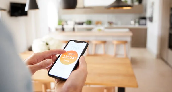 自宅で中央加熱温度を制御するためにスマートフォンアプリを使用して男の閉鎖 — ストック写真