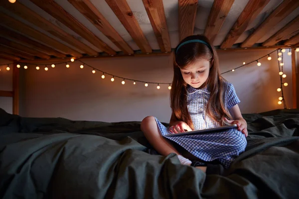 Menina Jovem Sentada Cama Casa Decorada Com Luzes Fadas Usando — Fotografia de Stock