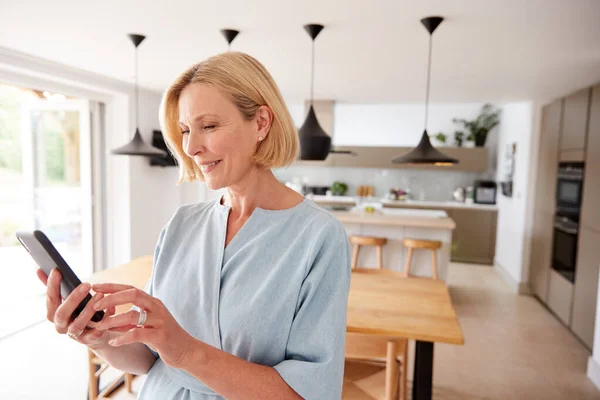 Reife Frau Mit App Auf Handy Zur Steuerung Der Zentralheizungstemperatur — Stockfoto