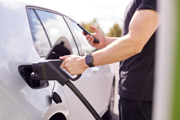 Man Opladen Van Elektrische Auto Met Kabel Zoek Naar App — Stockfoto