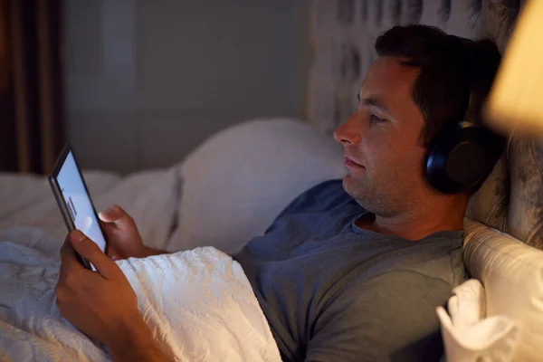 Homem Vestindo Fones Ouvido Sem Fio Deitado Cama Assistindo Tablet — Fotografia de Stock