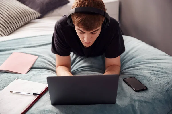 Estudante Universitário Masculino Usando Fones Ouvido Jaz Cama Casa Compartilhada — Fotografia de Stock