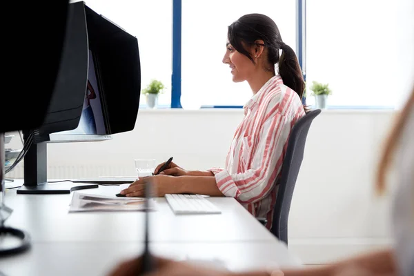 Женщина-ретушер работает за компьютером с помощью графического планшета в По — стоковое фото