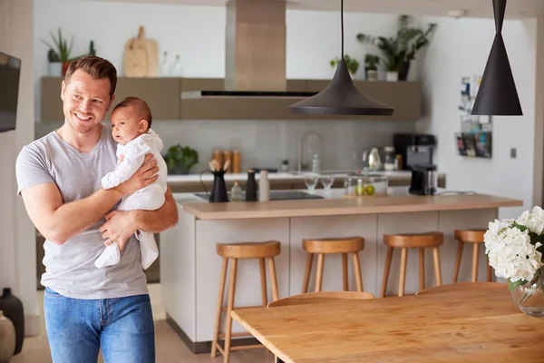 三个月大的女婴被爱的父亲抱在家里厨房里的画像 — 图库照片