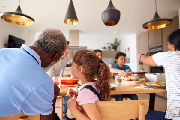 多世代混合レース家庭で一緒にテーブルの周りに食事を食べる家族 — ストック写真