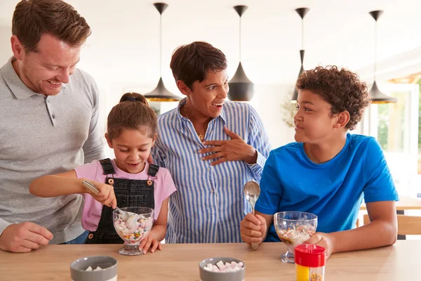 子供と一緒にキッチンで家族が作るとアイスクリームのデザートを食べる — ストック写真