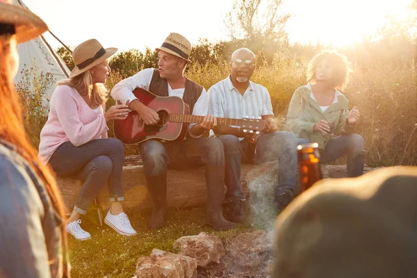 Bir Grup Olgun Arkadaş Ateşin Etrafında Oturmuş Dışarıda Içiyorlar Şarkı — Stok fotoğraf
