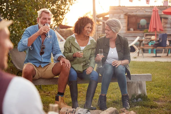在户外野营酒吧 一群成熟的朋友围坐在炉边喝酒 — 图库照片