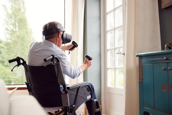 Evde Tekerlekli Sandalyedeki Olgun Adam Sanal Gerçeklik Kulaklığı Giyen Oyun — Stok fotoğraf