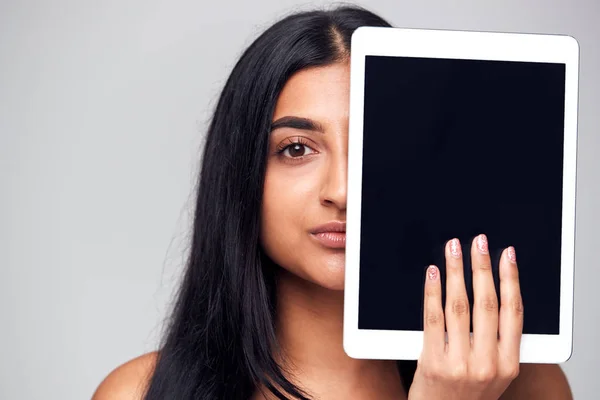 Studio Portret Poważnej Młodej Kobiety Zakrywającej Twarz Tabletem Cyfrowym — Zdjęcie stockowe