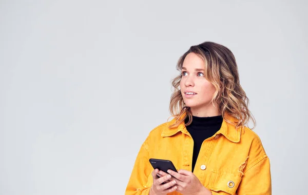 Estúdio Tiro Causally Vestido Jovem Mulher Usando Telefone Móvel Olhando — Fotografia de Stock