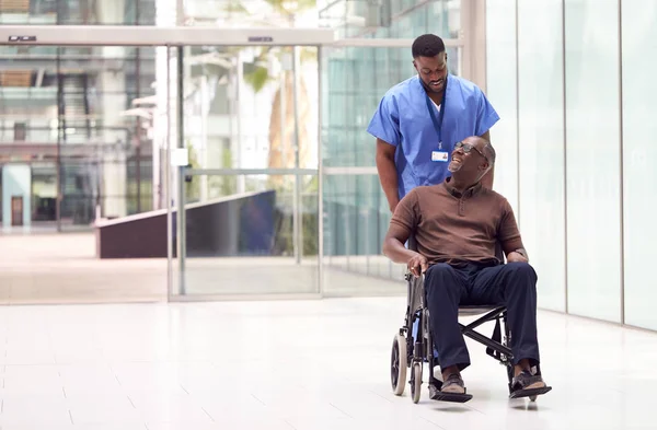 Manlig Sjuksköterska Bär Repor Rullande Patient Rullstol Genom Lobbyn Modern — Stockfoto