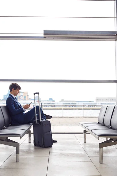 Biznesmen Siedzi Salonie Odlotów Lotniska Przy Użyciu Telefonu Komórkowego — Zdjęcie stockowe