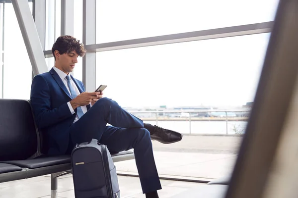 Empresario Sentado Salón Salida Del Aeropuerto Con Teléfono Móvil —  Fotos de Stock