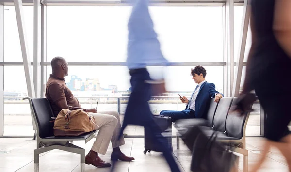 Pasażerowie Biznesowi Siedzą Zatłoczonym Salonie Odlotów Lotniska Przy Użyciu Telefonów — Zdjęcie stockowe
