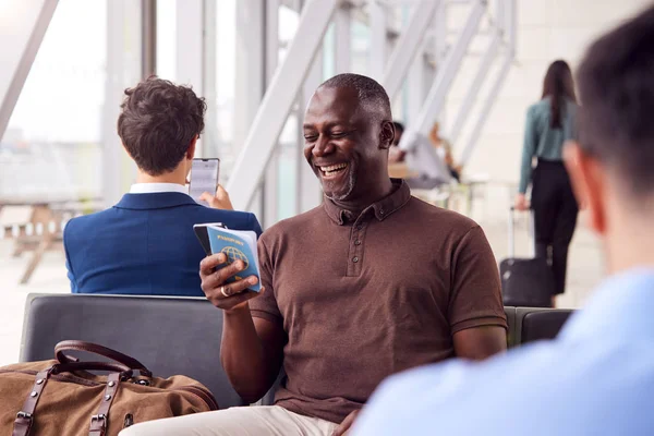 Biznesmen Siedzi Salonie Odlotów Lotniska Przy Użyciu Telefonu Komórkowego — Zdjęcie stockowe