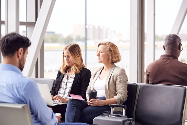 空港で働くビジネスマンラップトップで働く女性とコーヒーを飲む — ストック写真