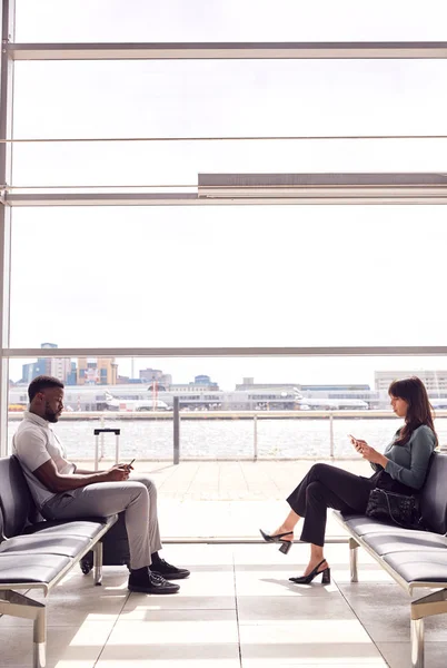 Επιχειρηματίας Και Επιχειρηματίας Που Κάθεται Στο Αεροδρόμιο Αναχώρηση Lounge Χρησιμοποιώντας — Φωτογραφία Αρχείου