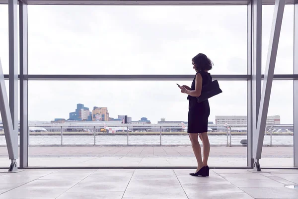 Rear View Businesswoman Using Mobile Phone Standing Window Airport Departure — Stock Photo, Image