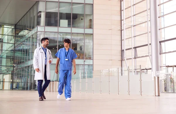 Equipe Médica Masculina Conversando Enquanto Caminham Pelo Átrio Edifício Moderno — Fotografia de Stock