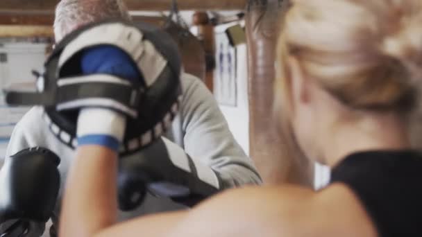 Senior Boxer Mit Jüngerer Trainerin Fitnessstudio Mit Trainingshandschuhen Schuss Zeitlupe — Stockvideo