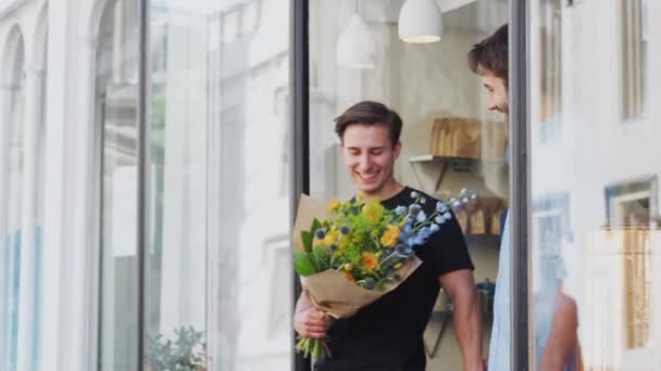 愛する男性ゲイカップルが花の束を保持している花から出てくる 遅い動きで撮影 — ストック動画