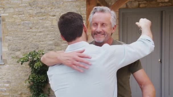 Старший Отец Приветствует Взрослого Сына Перед Входной Дверью Дома Приходит — стоковое видео
