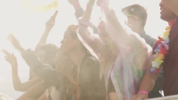 煙のフレアで音楽祭のサイトで障壁の後ろに踊る若い友人のグループ スローモーションで撮影 — ストック動画