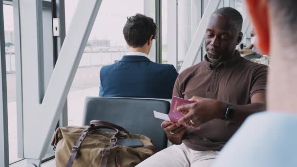 空港出発ラウンジに座っているビジネスマンは フライトの前に旅行書類を確認してください スローモーションで撮影 — ストック動画